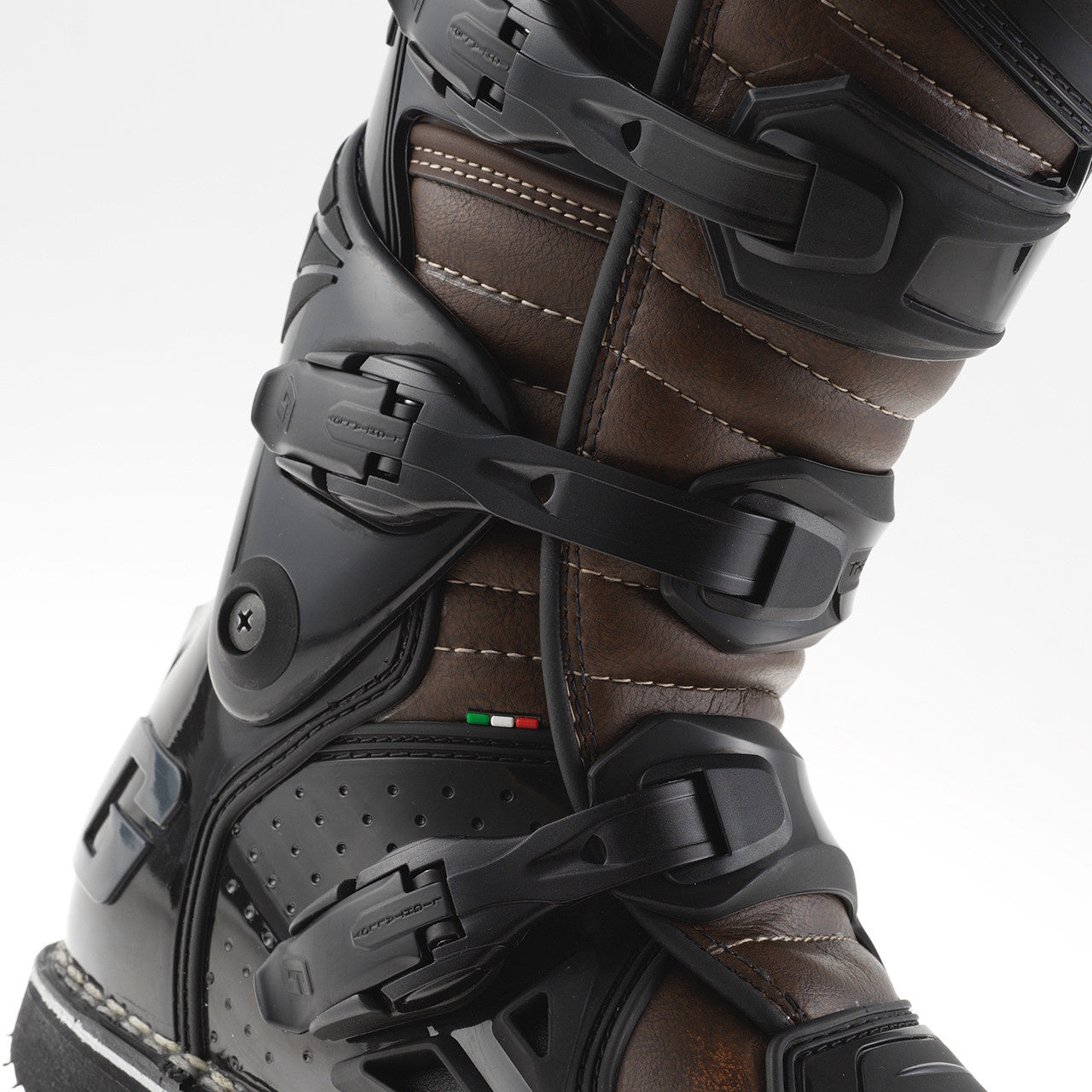 Close-up of a brown and black ski boot with bindings on a white background