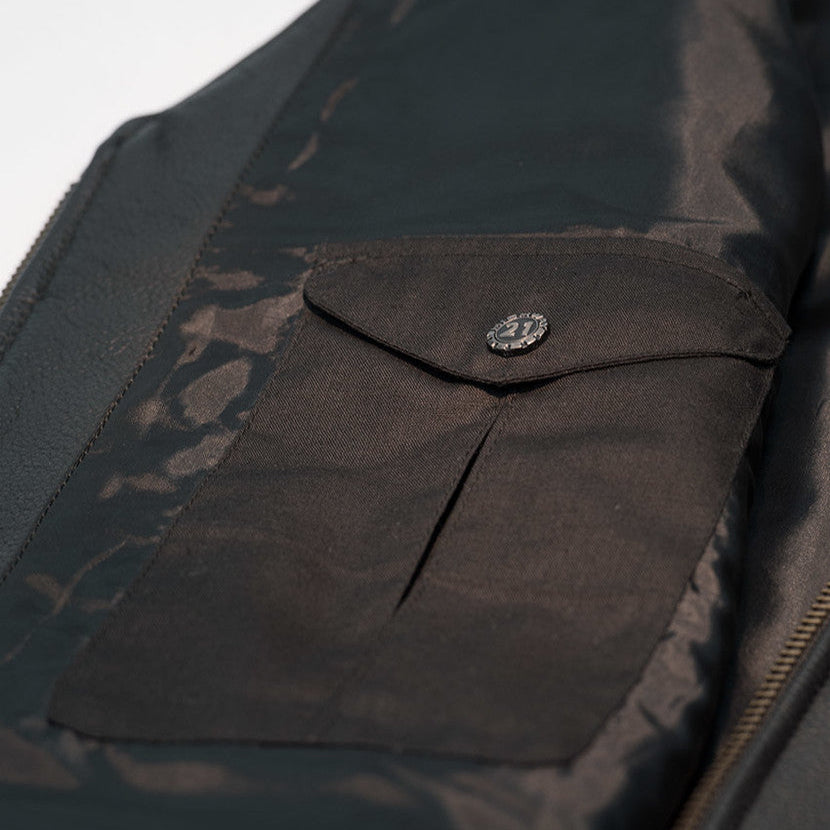 Close-up of a dark jacket with a buttoned pocket against a light background