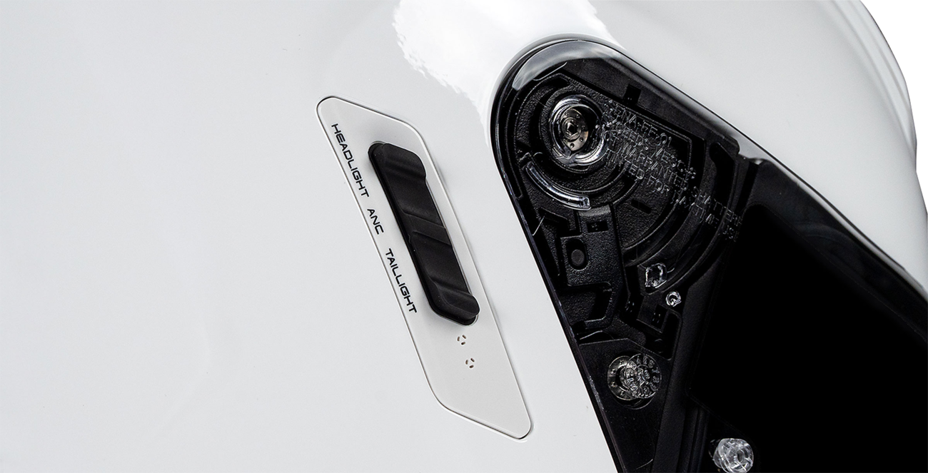 Close-up of a motorcycle headlight assembly on a white background