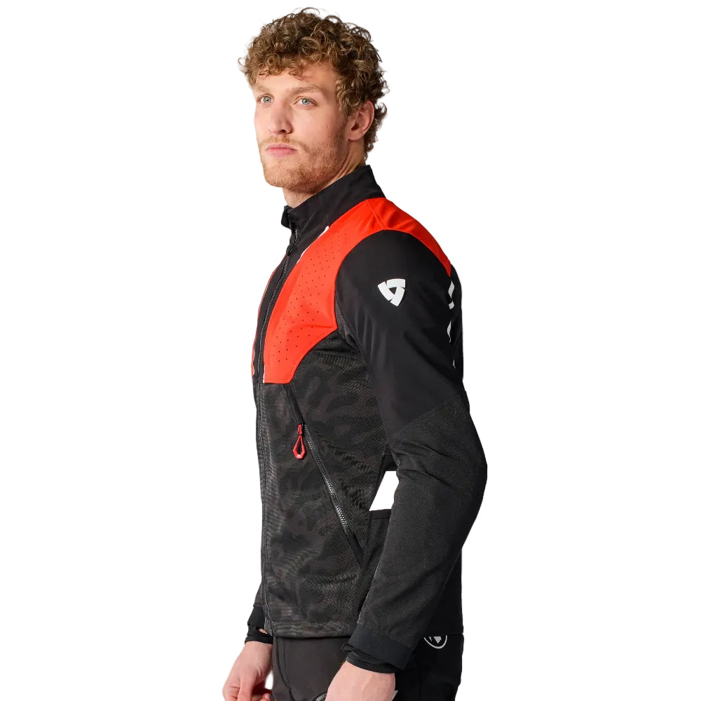 Man wearing a black and red jacket with a logo on a white background