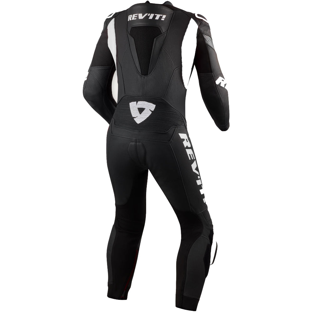 Black and white REV'IT! full-body racing suit shown from the back, featuring white logo branding and a white shield logo on the back and upper thigh.
