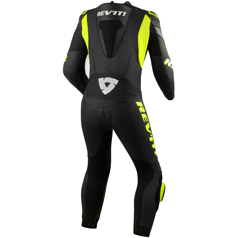 A black full-body racing suit with high-visibility neon yellow accents and white REV'IT! branding, shown from the back on a white background.