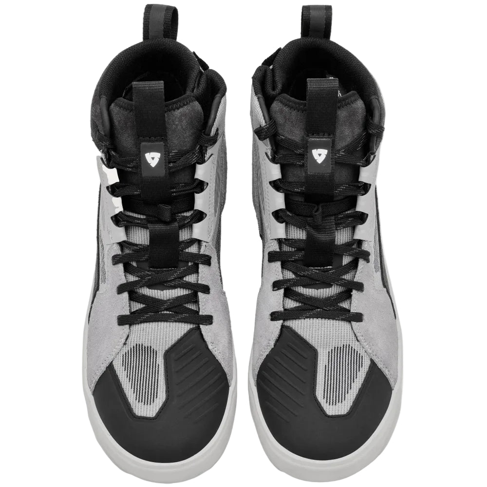 A pair of high-top sneakers shown from a top-down view, featuring a color-blocked design in light gray, black, and white, with textured panels and black laces, set against a solid off-white background.