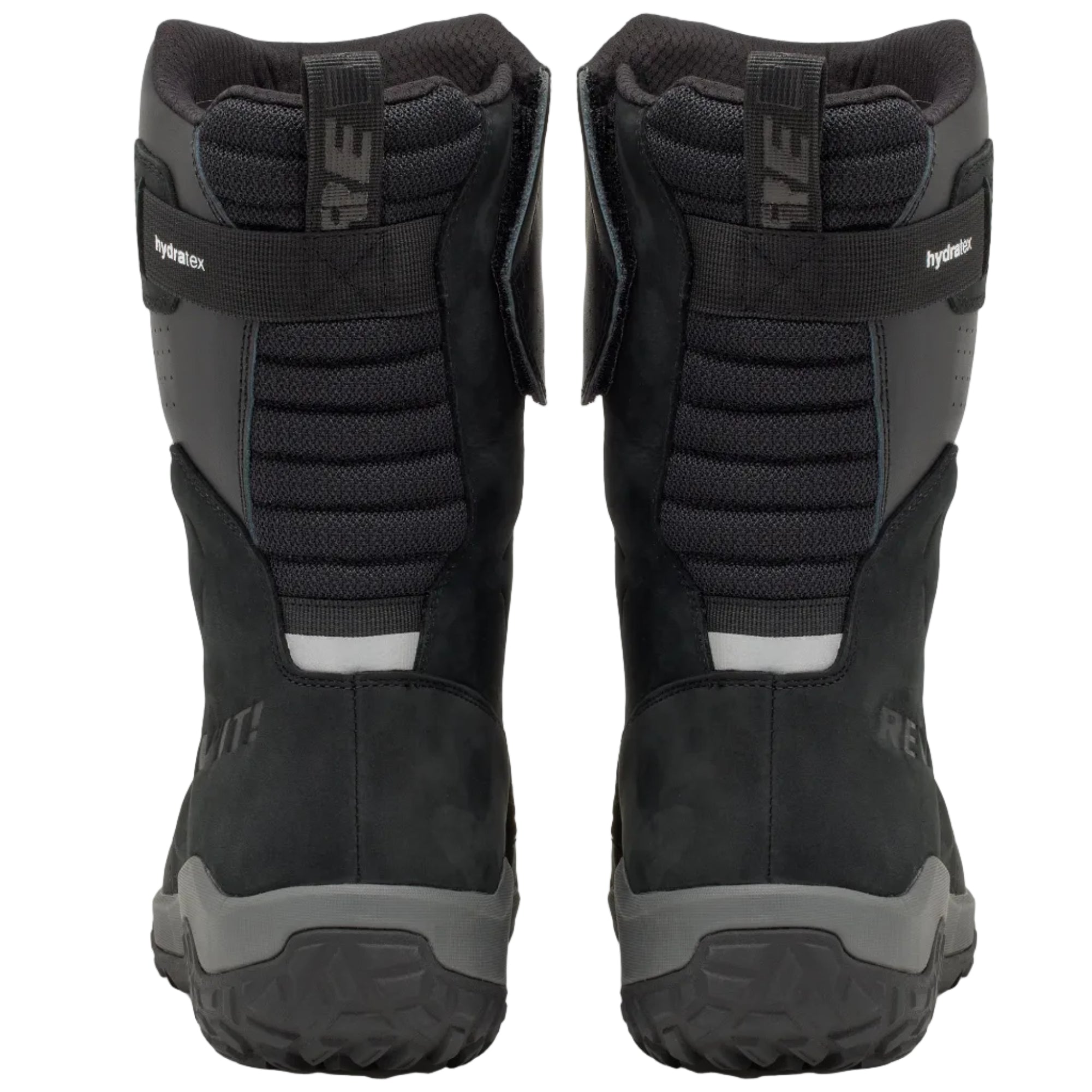 A pair of black and dark gray snowmobile boots shown from the back, featuring textured panels, a hook-and-loop strap closure, and rugged tread soles, set against a light off-white background.
