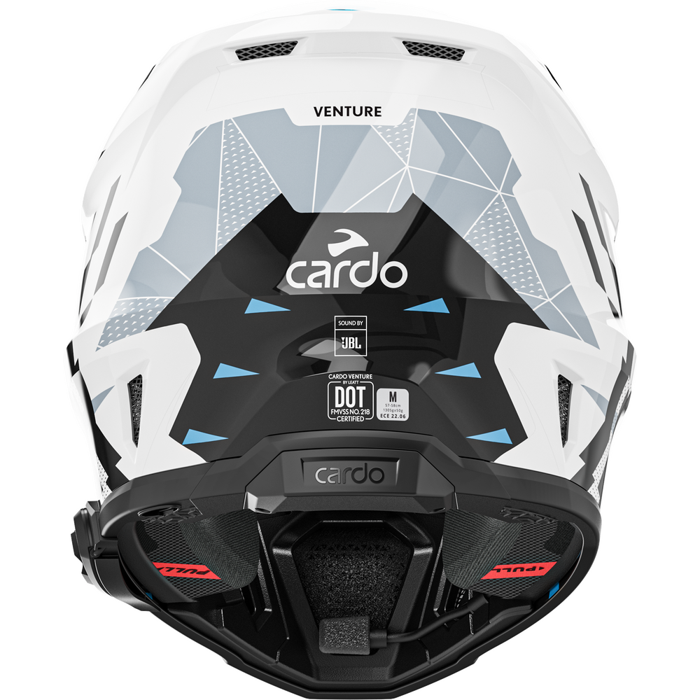 A close-up rear view of a white, black, and gray full-face motorcycle helmet with geometric patterns and blue accents, featuring the Cardo brand logo and various certification stickers.