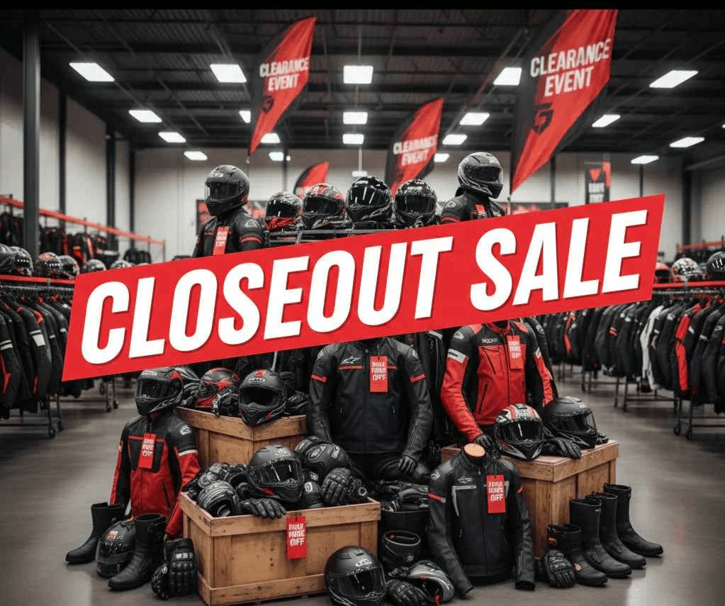 Motorcycle gear clearance sale with 'Closeout Sale' sign in a warehouse.