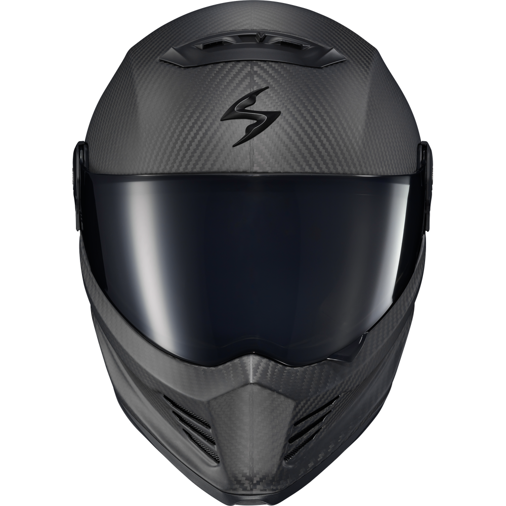 A full-face motorcycle helmet in matte black carbon fiber with a dark tinted visor and a stylized black logo on the forehead, shown against a plain white background.