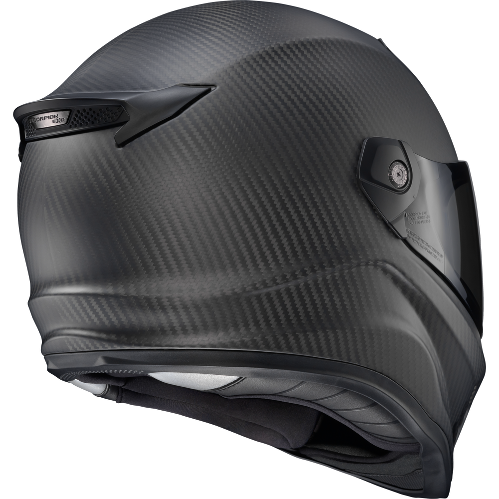 A full-face motorcycle helmet with a matte black carbon fiber weave pattern, featuring a visor and chin strap, shown from a three-quarters angle on a white background.