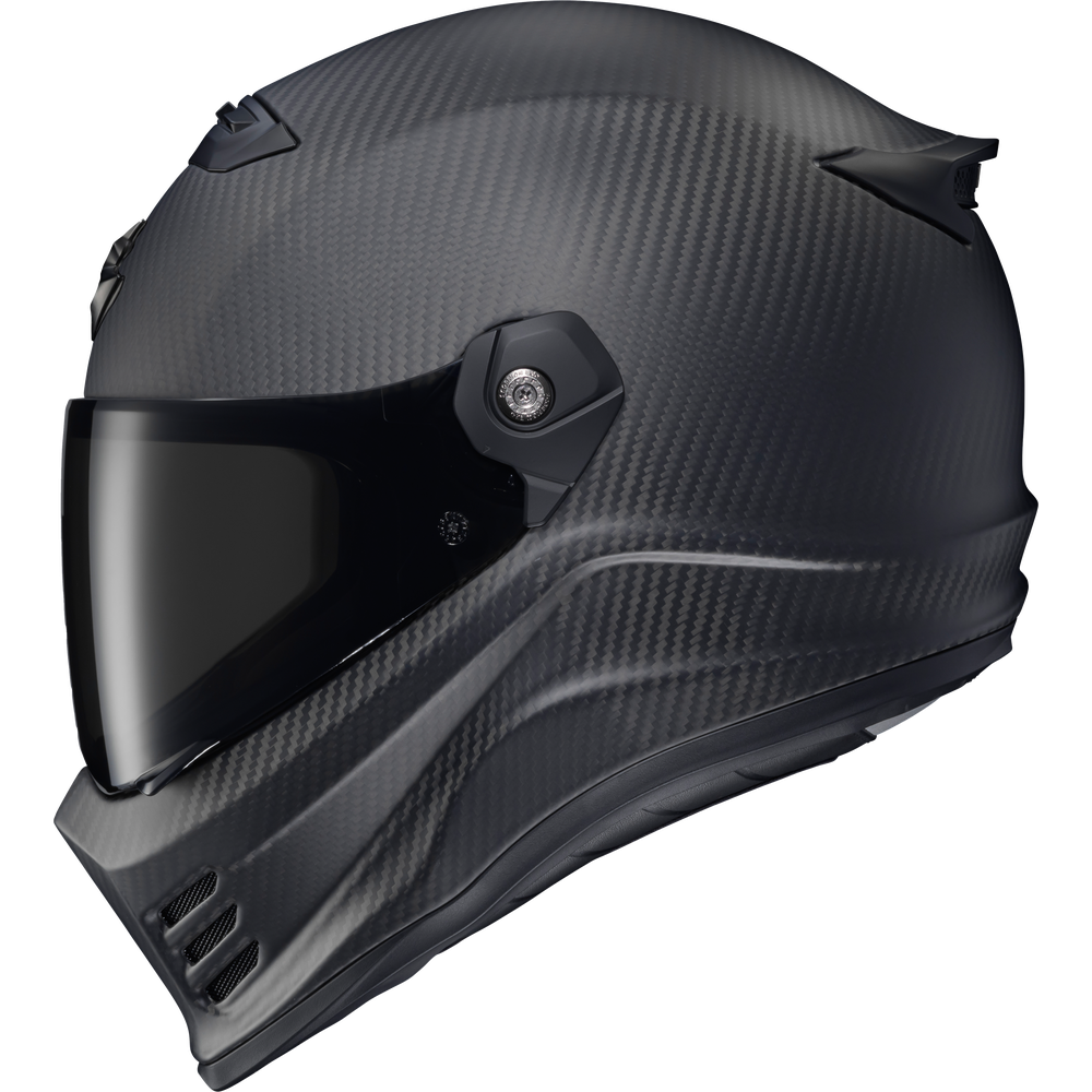 A full-face motorcycle helmet with a matte black carbon fiber pattern, featuring a dark visor and a side ventilation valve, shown against a plain white background.