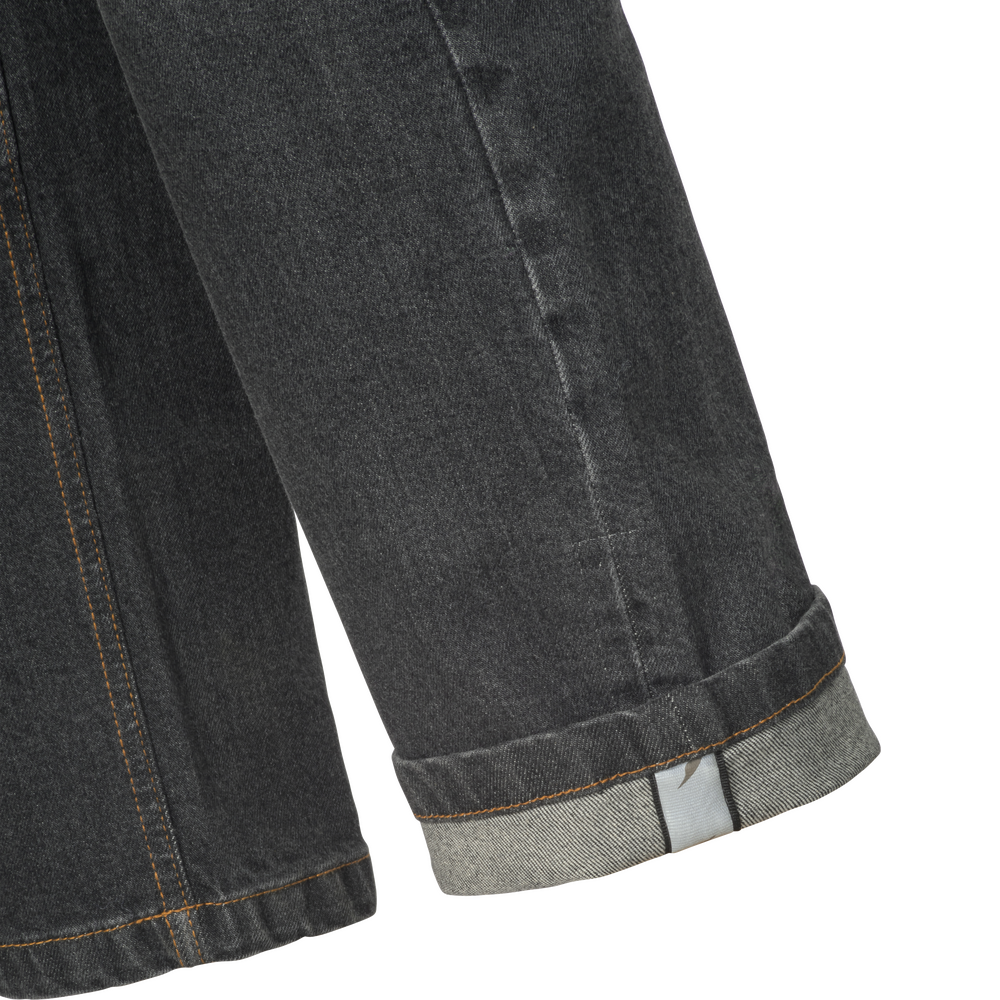 Close-up of a dark gray denim leg with a rolled cuff showing the lighter inner denim layer and contrast stitching, on a white background.