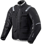 A black and gray Revit motorcycle jacket with reflective gray stripes, multiple zippered pockets, and a high collar, shown on a plain white background.