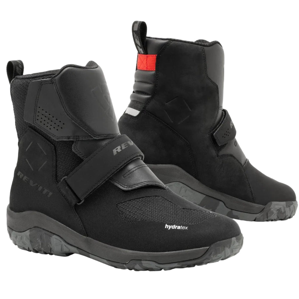 Black motorcycle boots with strap details on a white background
