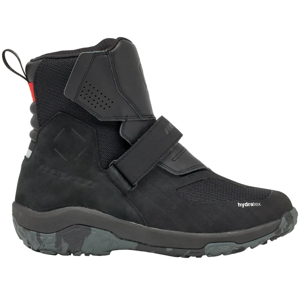 Black high-top sneaker with velcro straps on a light gray background