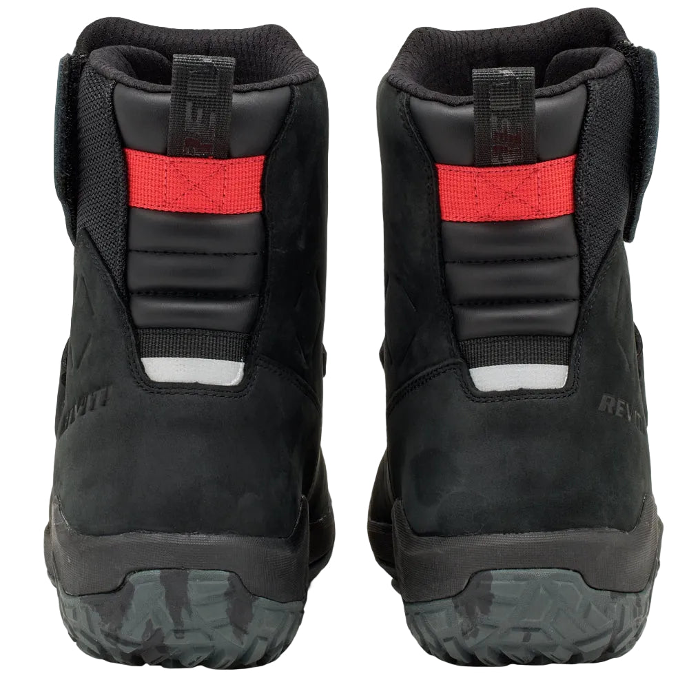 Black winter boots with red accents on a light gray background