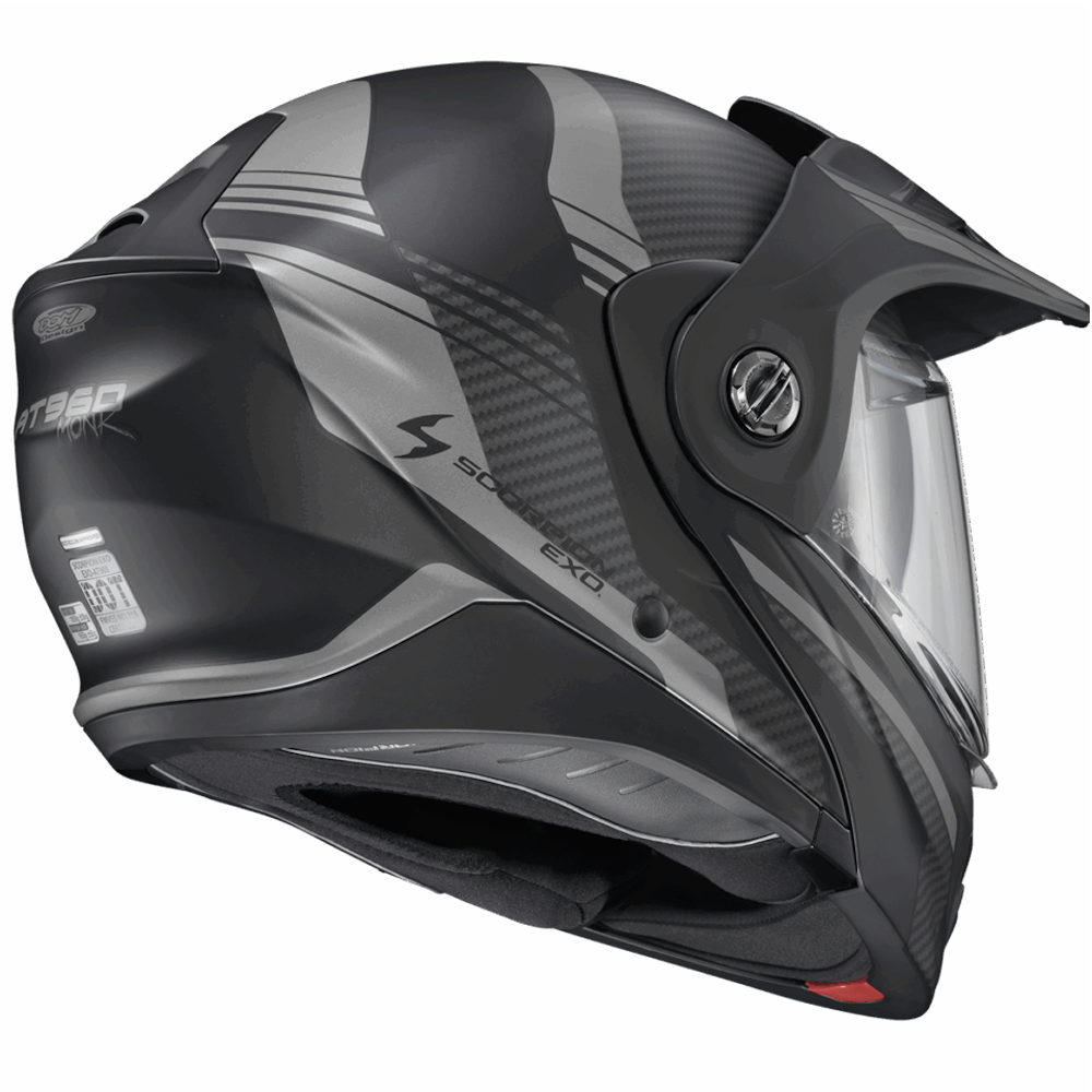 A side profile view of a Scorpion EXO full-face motorcycle helmet in matte black and dark gray with carbon fiber textures, featuring a clear visor.