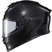 A full-face motorcycle helmet with a glossy black carbon fiber pattern, featuring a clear visor and a small red accent near the chin, shown against a plain white background.