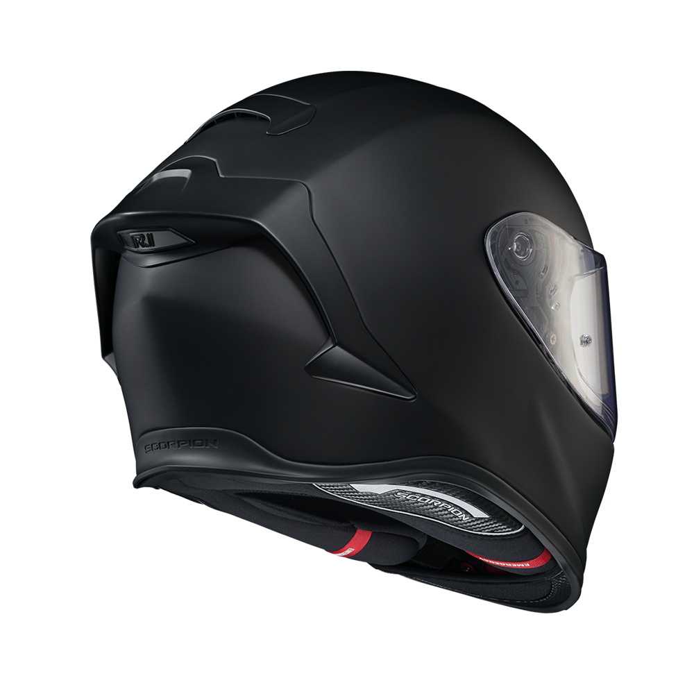 A matte black full-face motorcycle helmet shown from a three-quarters rear angle, featuring a clear visor and subtle red accents near the chin, set against a plain white background.