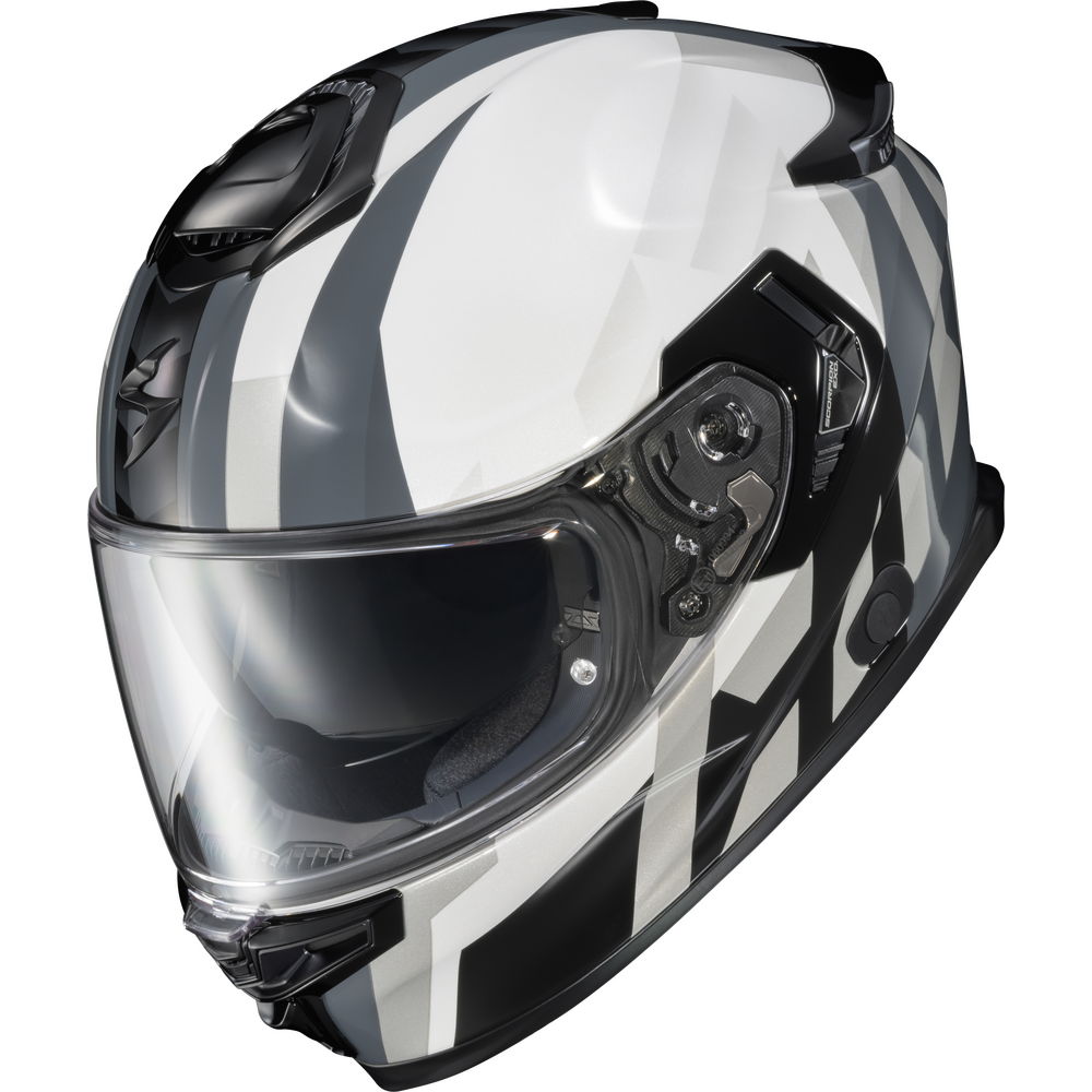 A full-face motorcycle helmet with a glossy white, black, and gray geometric pattern, featuring a clear visor and black chin bar, shown on a solid white background.