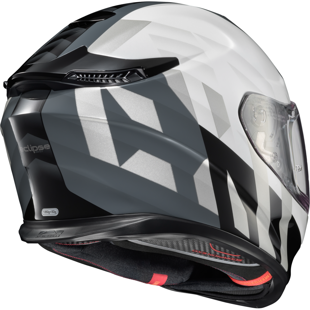 A full-face motorcycle helmet with a white, gray, and black geometric pattern, featuring a clear visor and a dark interior.