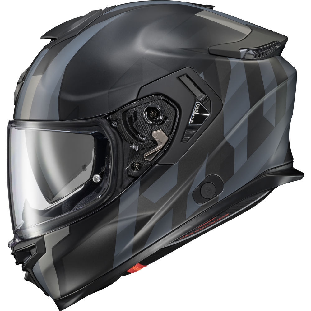 A full-face motorcycle helmet in a matte black finish with a subtle gray geometric pattern on the side, featuring a clear visor.