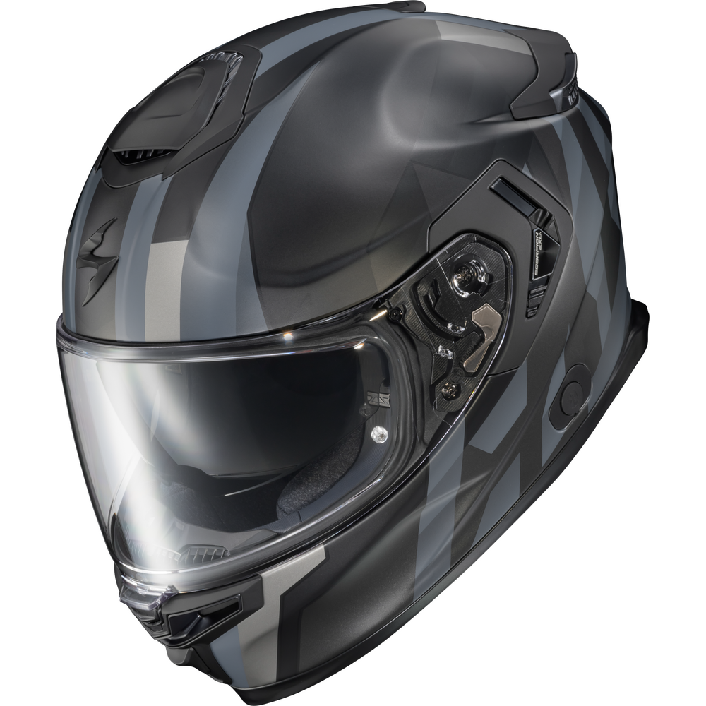 A full-face motorcycle helmet in a glossy dark gray and black colorway with subtle geometric patterns, featuring a clear visor and visible side ventilation controls, set against a plain white background.