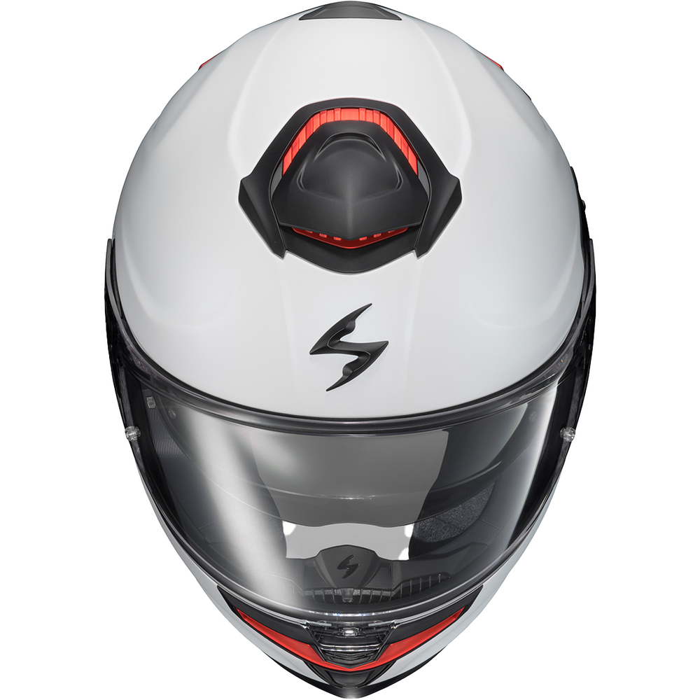 A white full-face motorcycle helmet with a clear visor, featuring a black stylized logo on the forehead and red accent details around the top vent and lower chin area.