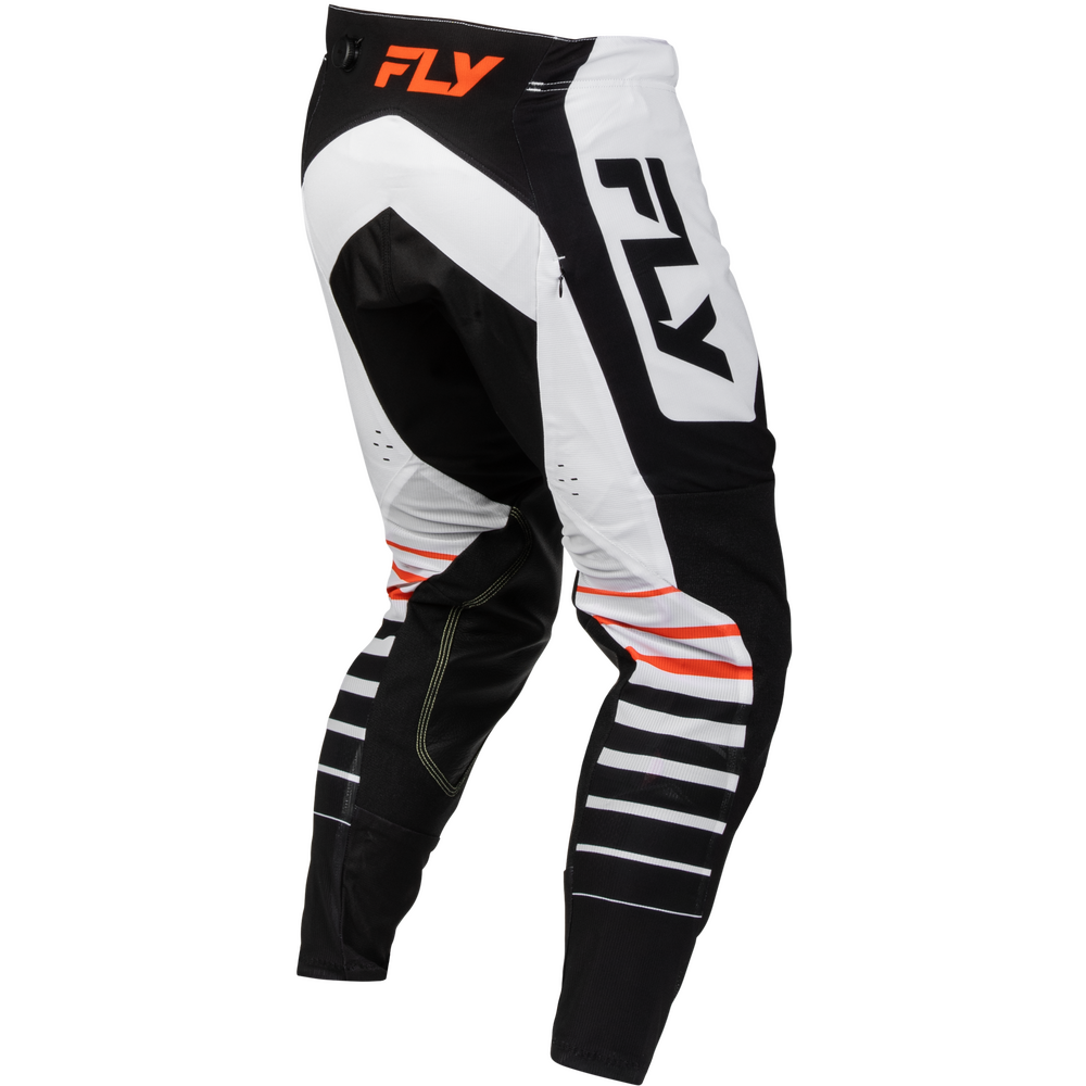 Black and white motocross pants with orange and black FLY branding, shown from a three-quarters angle on a white background.