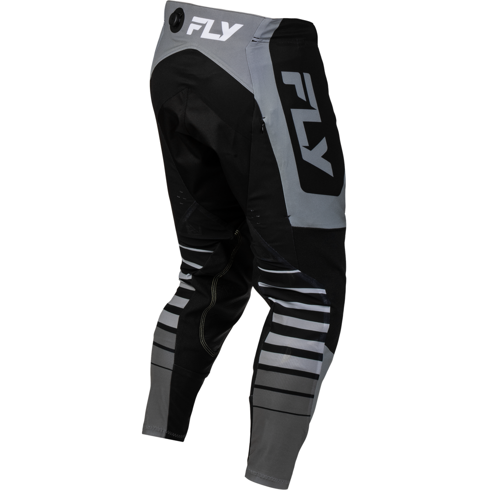 Black and gray Fly motocross pants with a large white FLY logo on the side and back, shown on a plain white background.