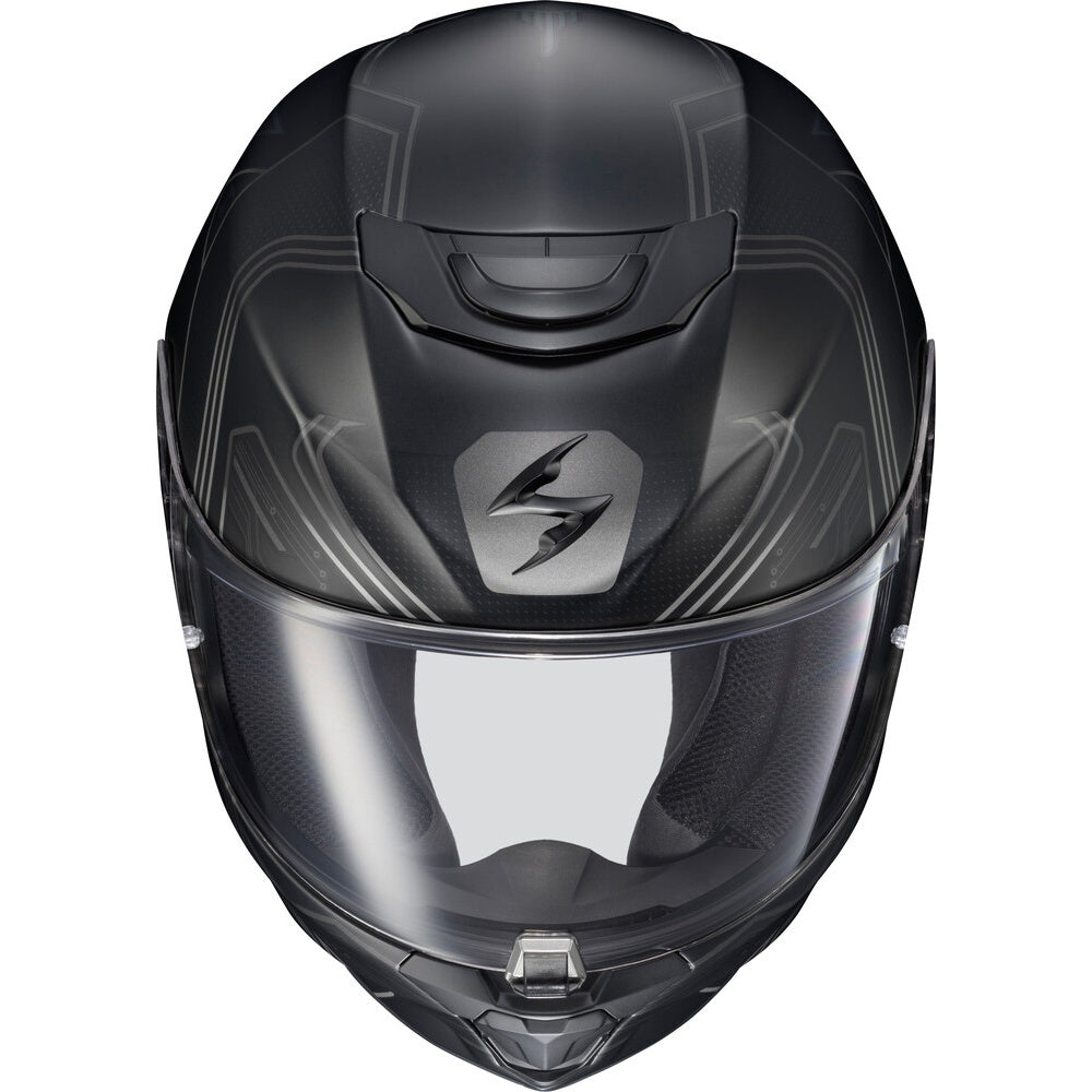 A matte black full-face motorcycle helmet with a clear visor, featuring a stylized silver logo on the forehead and subtle gray graphic lines on the shell.