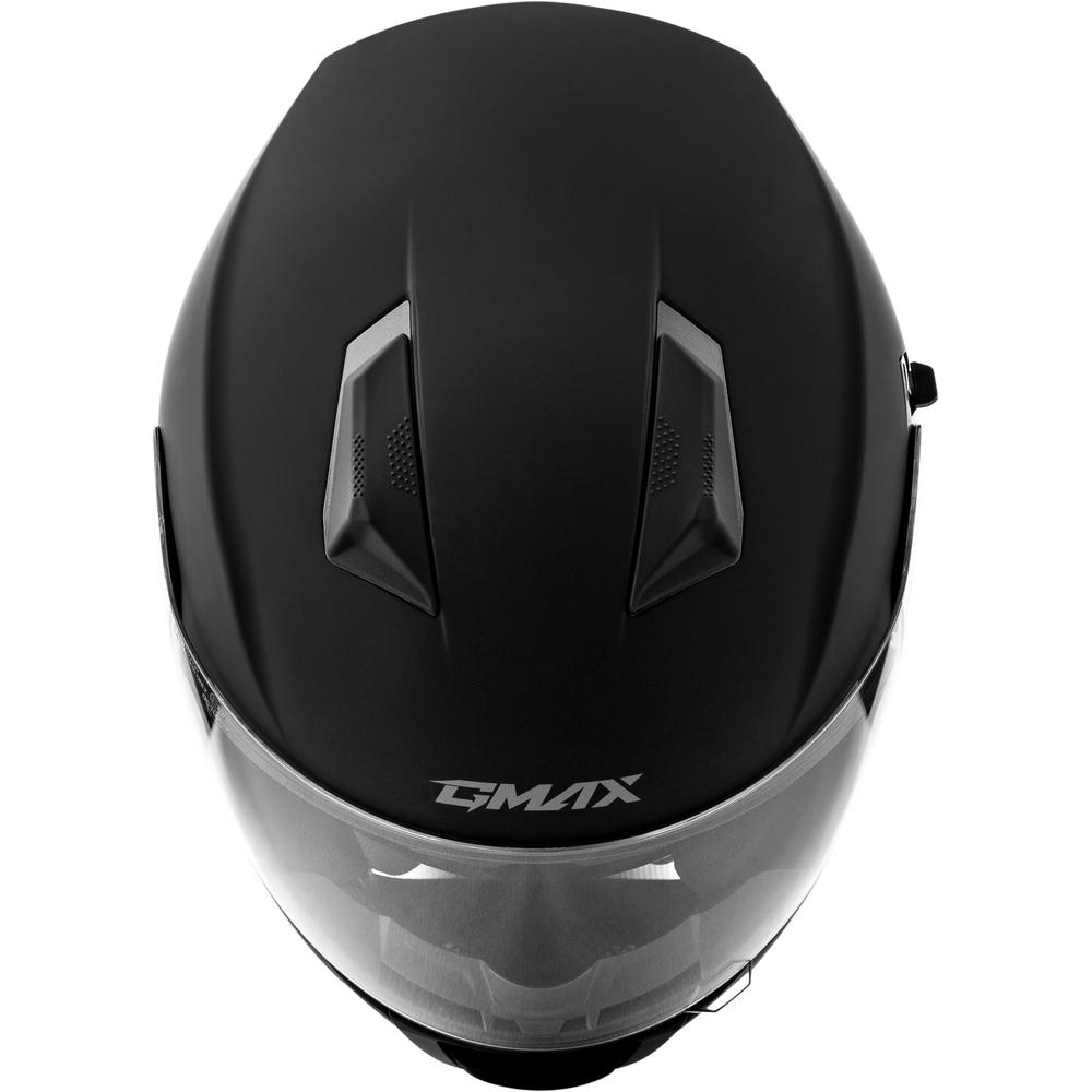 Matte black full-face motorcycle helmet with a clear visor and the GMAX logo printed in white on the lower front, shown from a top-down angle against a white background.
