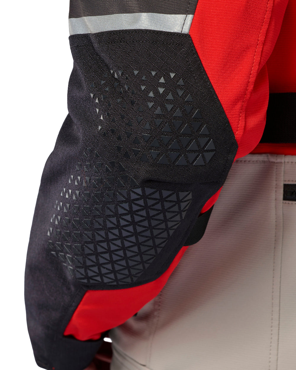 Close-up of a red and black protective jacket sleeve with a textured black geometric mesh panel and reflective silver stripe.