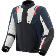 A technical motorcycle jacket in navy blue, white, and black with red accents, featuring a high collar, front zipper, and visible 'Revit' branding on the sleeve.