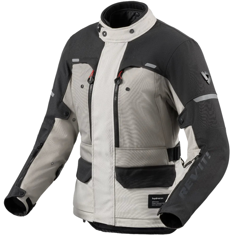 A technical motorcycle jacket in a two-tone gray and black colorway, featuring a high collar, multiple zippered pockets, and the Rev'it! brand name printed vertically on the right sleeve.