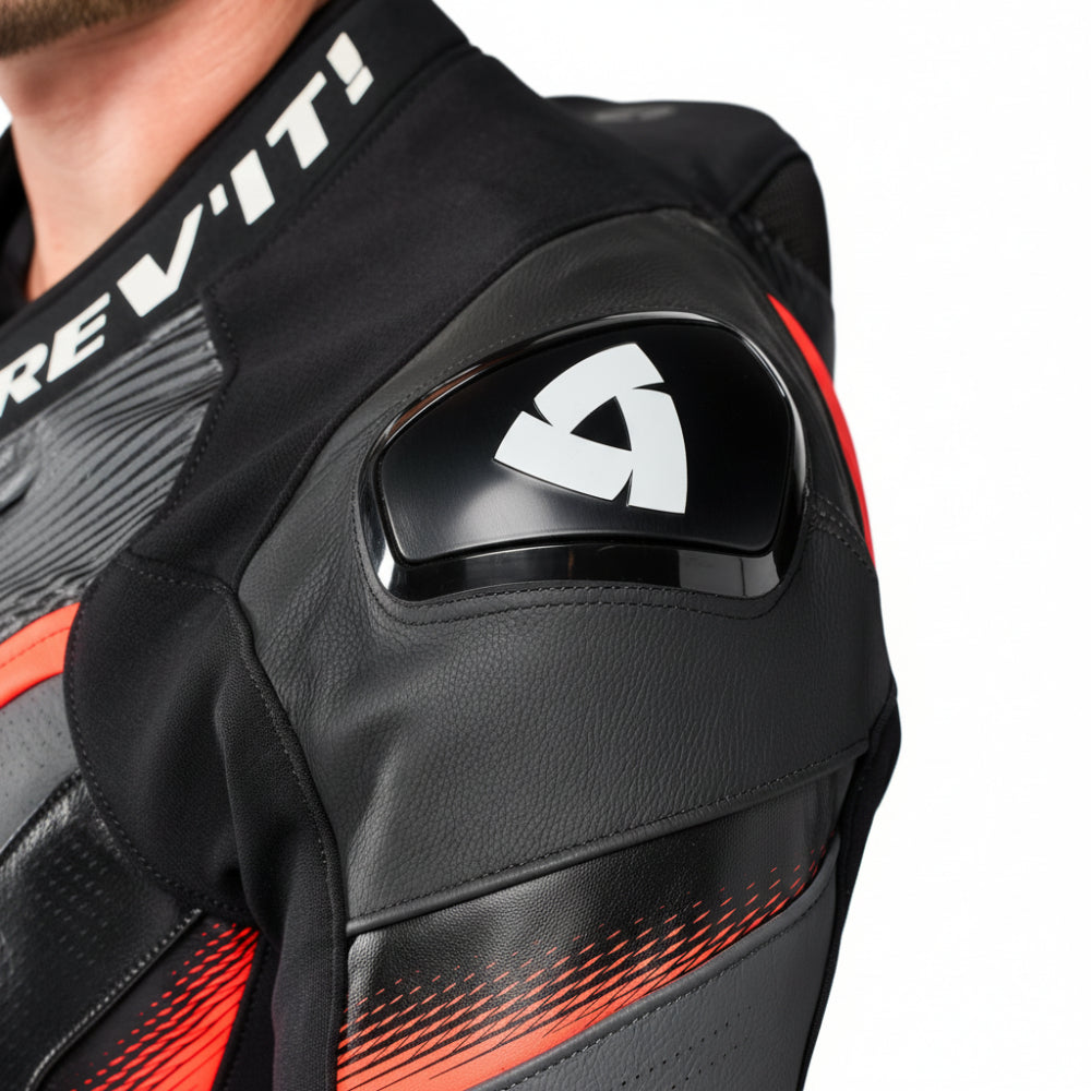 Close-up of a black leather motorcycle jacket with red accents and a white Dev'it! logo on the shoulder, worn by a model.