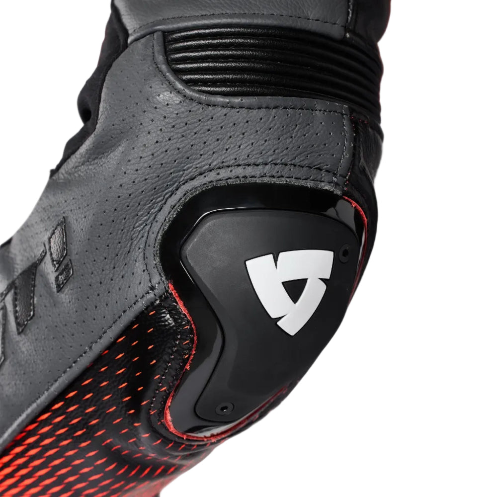 Close-up of a black and red motorcycle glove with a brand logo on a gray background