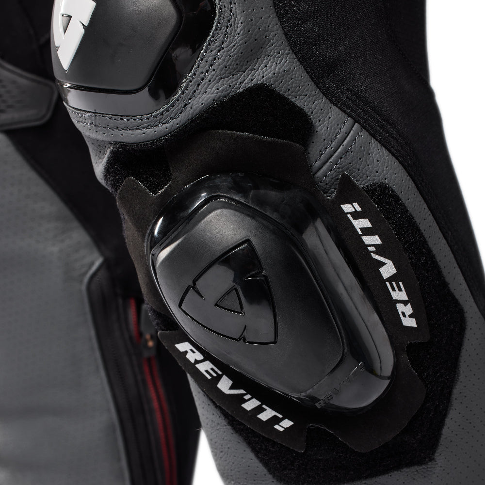Close-up of a motorcycle boot featuring black and dark gray protective armor with the REV-VIT! brand name in white on black pads.