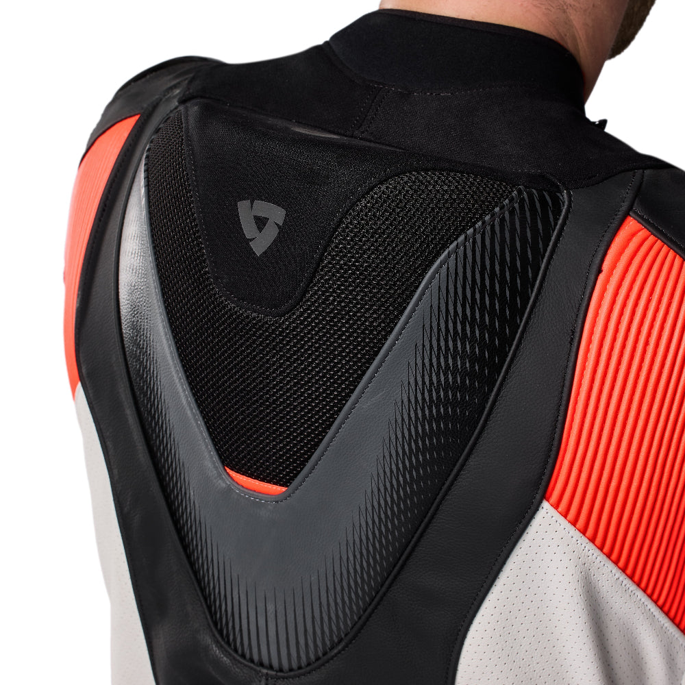 Close-up back view of a motorcycle jacket showing protective armor inserts, mesh panels, and color blocking in black, gray, white, and bright orange-red on a white background.