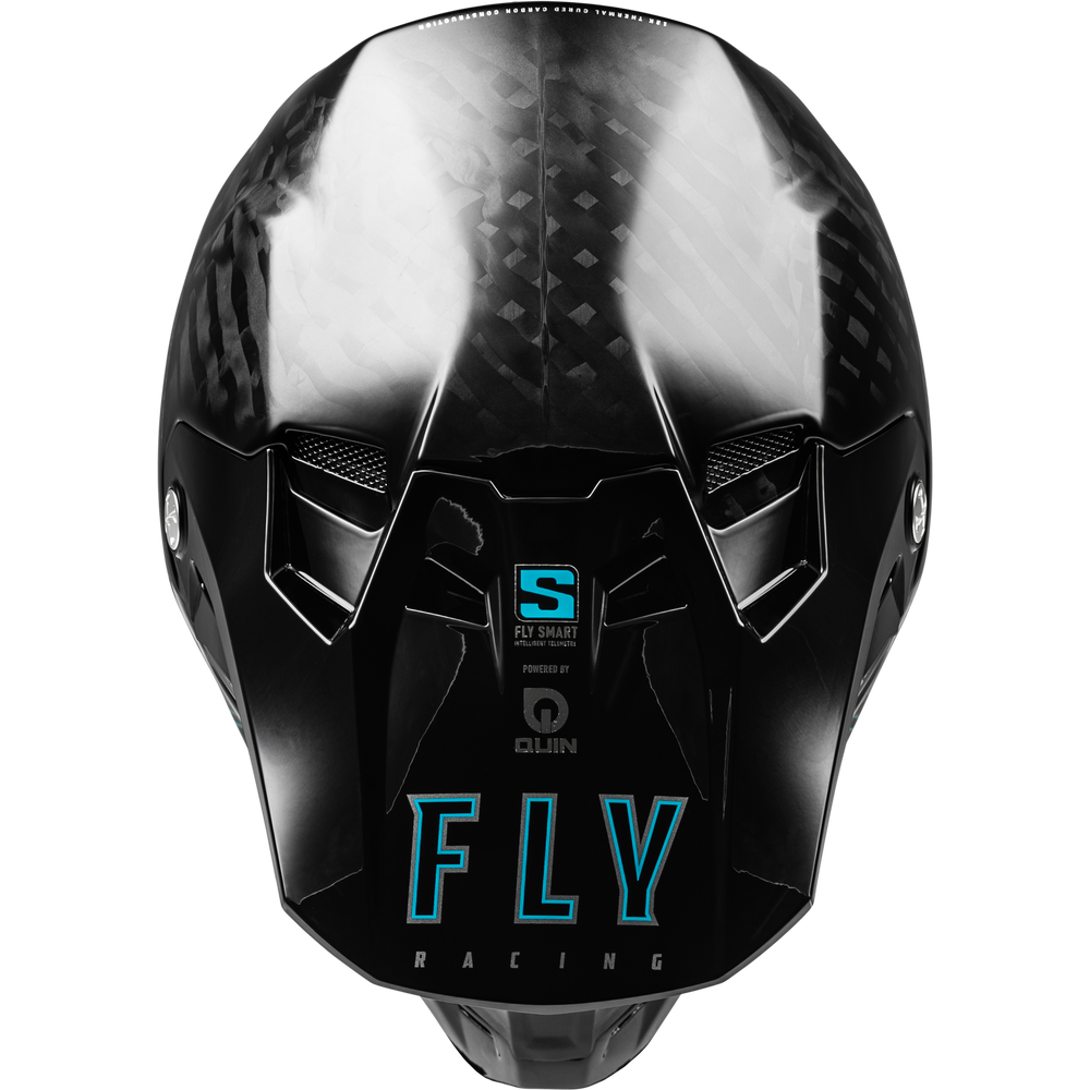 A glossy black full-face racing helmet with a carbon fiber pattern on the upper shell, featuring a large turquoise 'FLY' logo and 'RACING' text on the front, along with 'S-DRAG' and 'QUIN' branding.