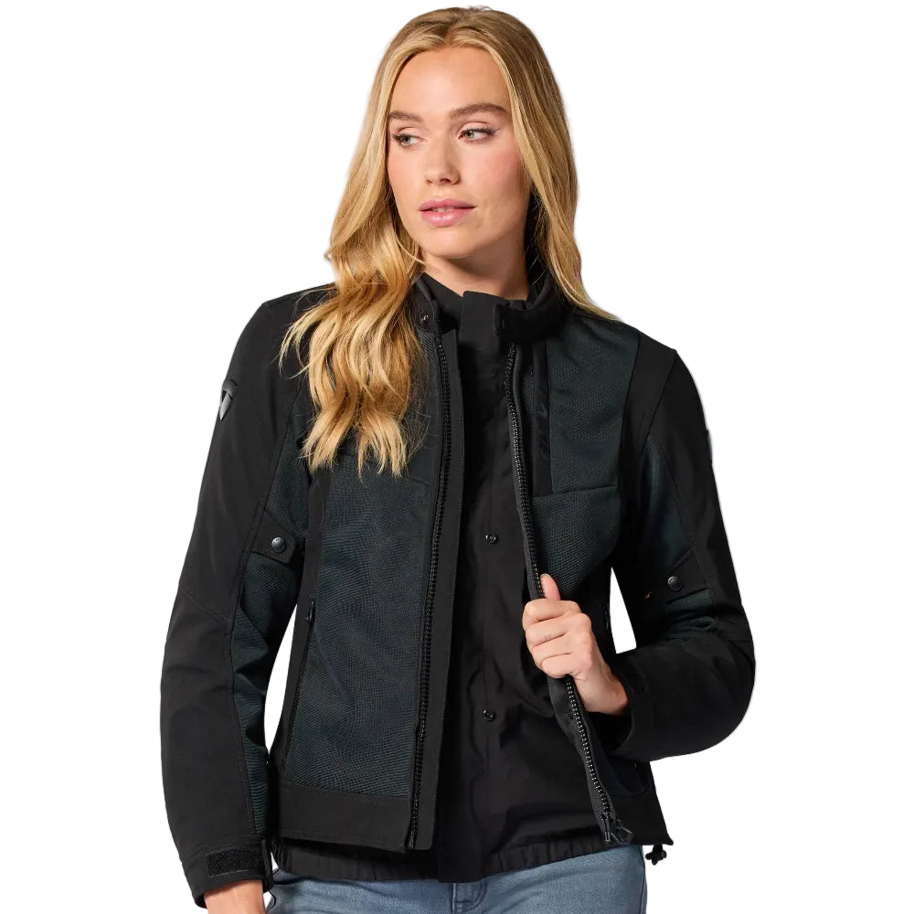 A woman modeling a black motorcycle jacket with a high collar, front zipper, and snap-button chest pockets, shown against a plain white background.