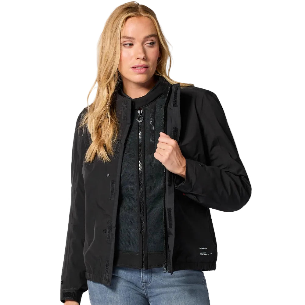 Woman wearing a black jacket and light blue jeans on a white background
