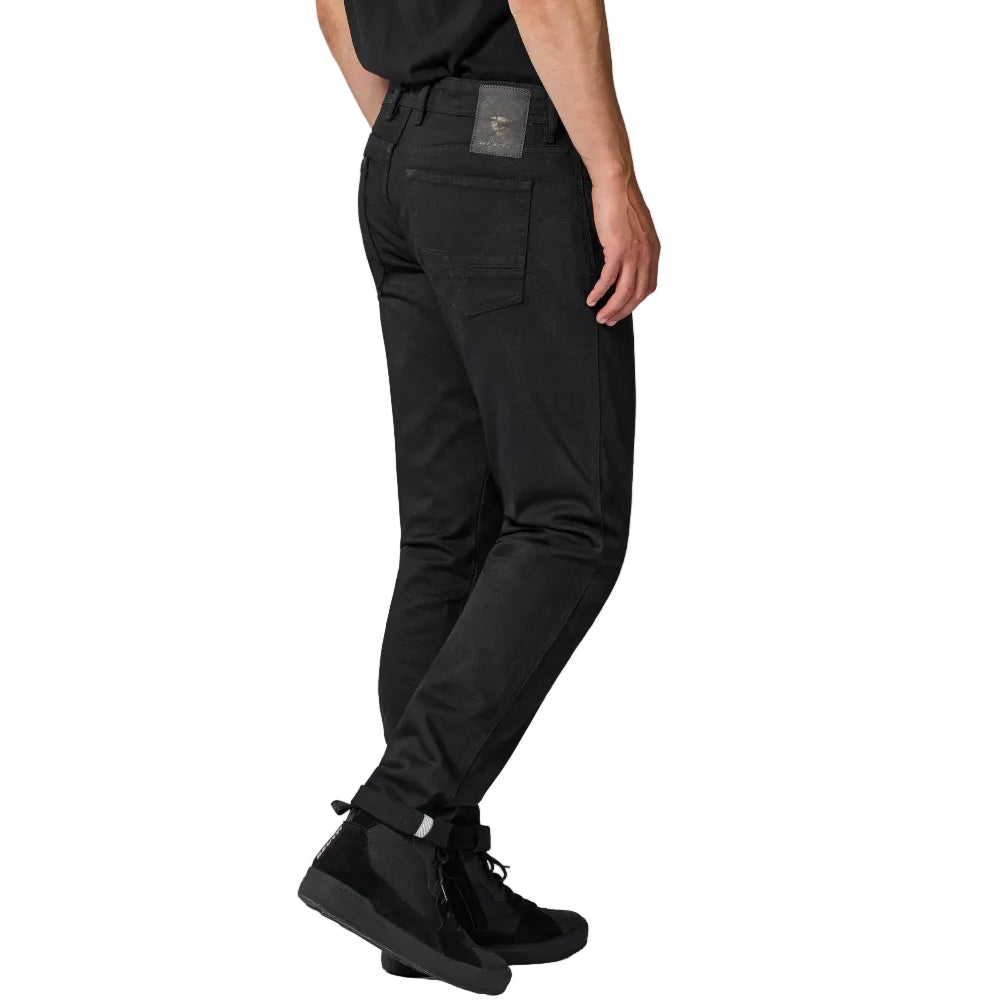 Person wearing black pants and black shoes on a white background