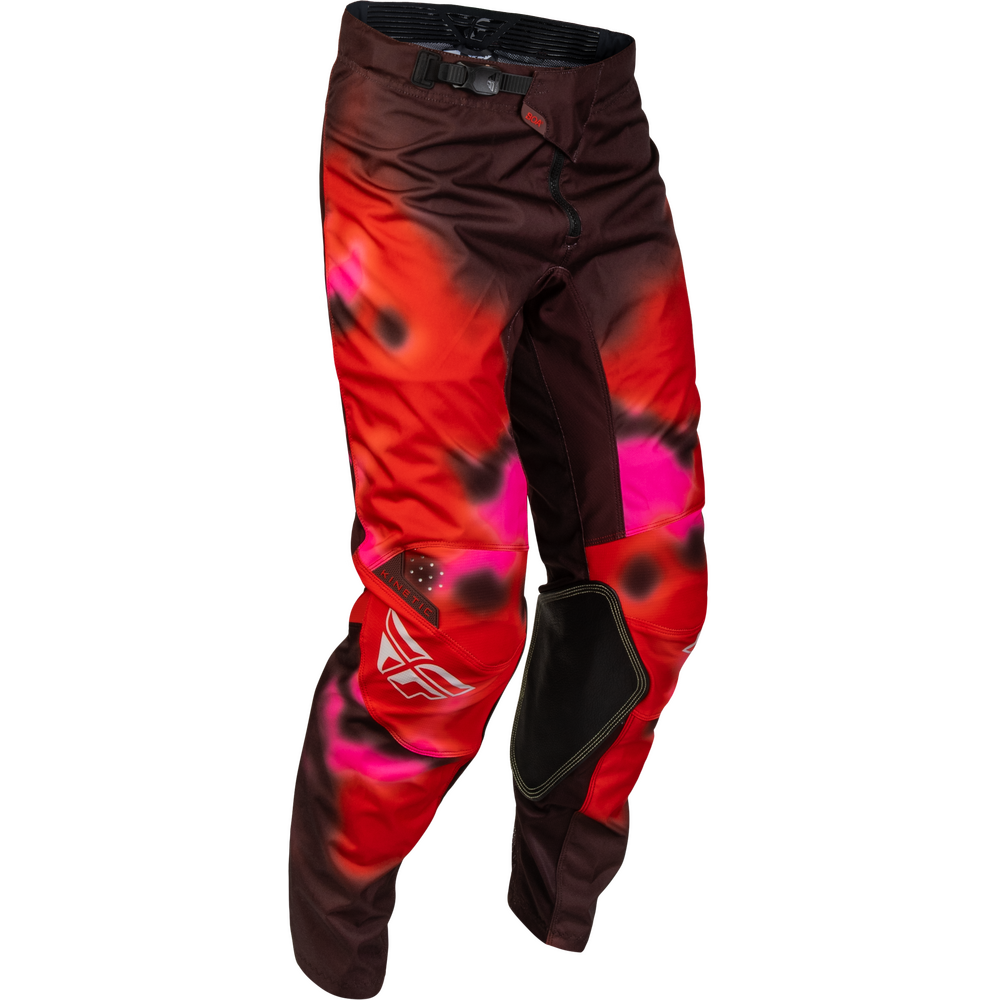 Red and pink motocross pants with black and white flame-like patterns, featuring a black knee pad and a white stylized logo on the lower left leg, shown against a plain white background.