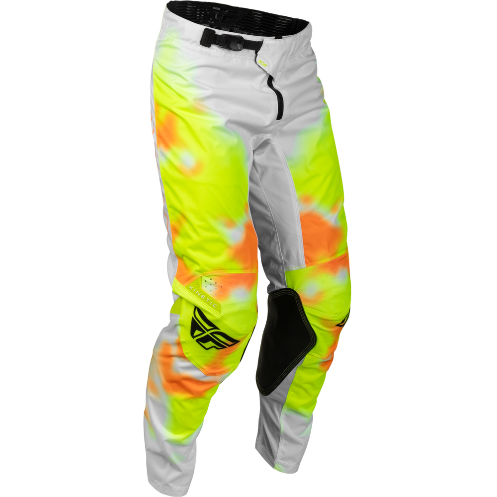 A pair of motocross pants featuring a high-visibility neon yellow and orange tie-dye pattern over a light gray base, with black knee pads and a black logo on the lower left leg.