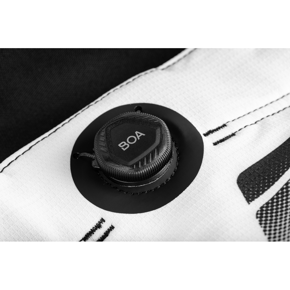 Close-up of a black circular valve cap labeled BOA mounted on a white textured fabric surface with black stitched detailing.