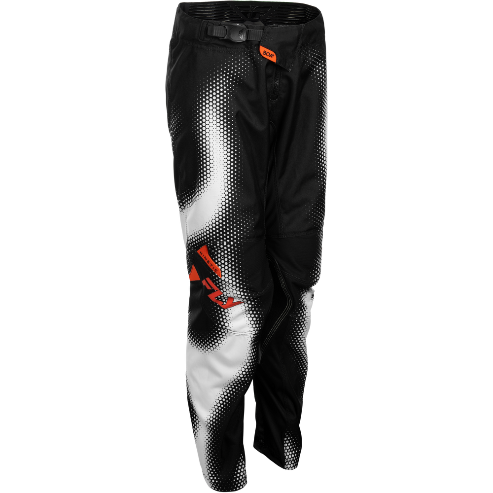 Black and white halftone motocross pants with a small orange logo on the upper thigh and a larger orange logo on the lower leg, shown against a plain white background.