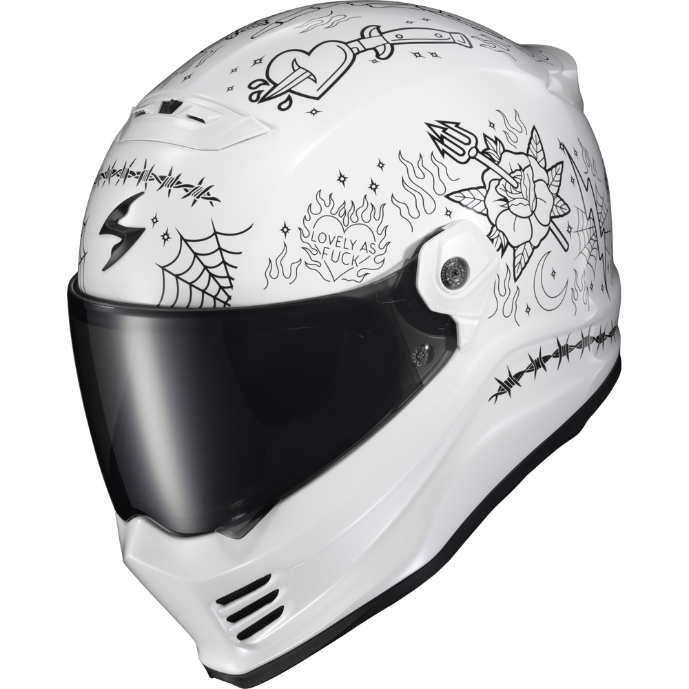 A white full-face motorcycle helmet decorated with black line-art illustrations and text, including a heart, spiderwebs, flames, a rose, and the phrase 'LOVELY AS A ROCK'. The helmet has a dark tinted visor and is photographed on a clean white background.
