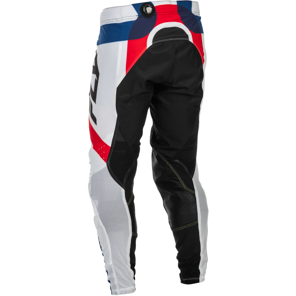 A pair of motocross pants shown from the back, featuring a color-blocked design of white, black, red, and blue with a dial closure at the waist.