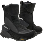 A pair of black REV'IT! mid-calf boots with textured panels and a small yellow Vibram logo on the toe, displayed against a light off-white background.