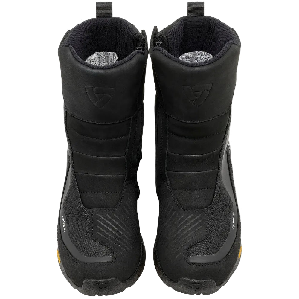 A pair of black mid-calf motorcycle boots shown from a top-down view against a light off-white background.