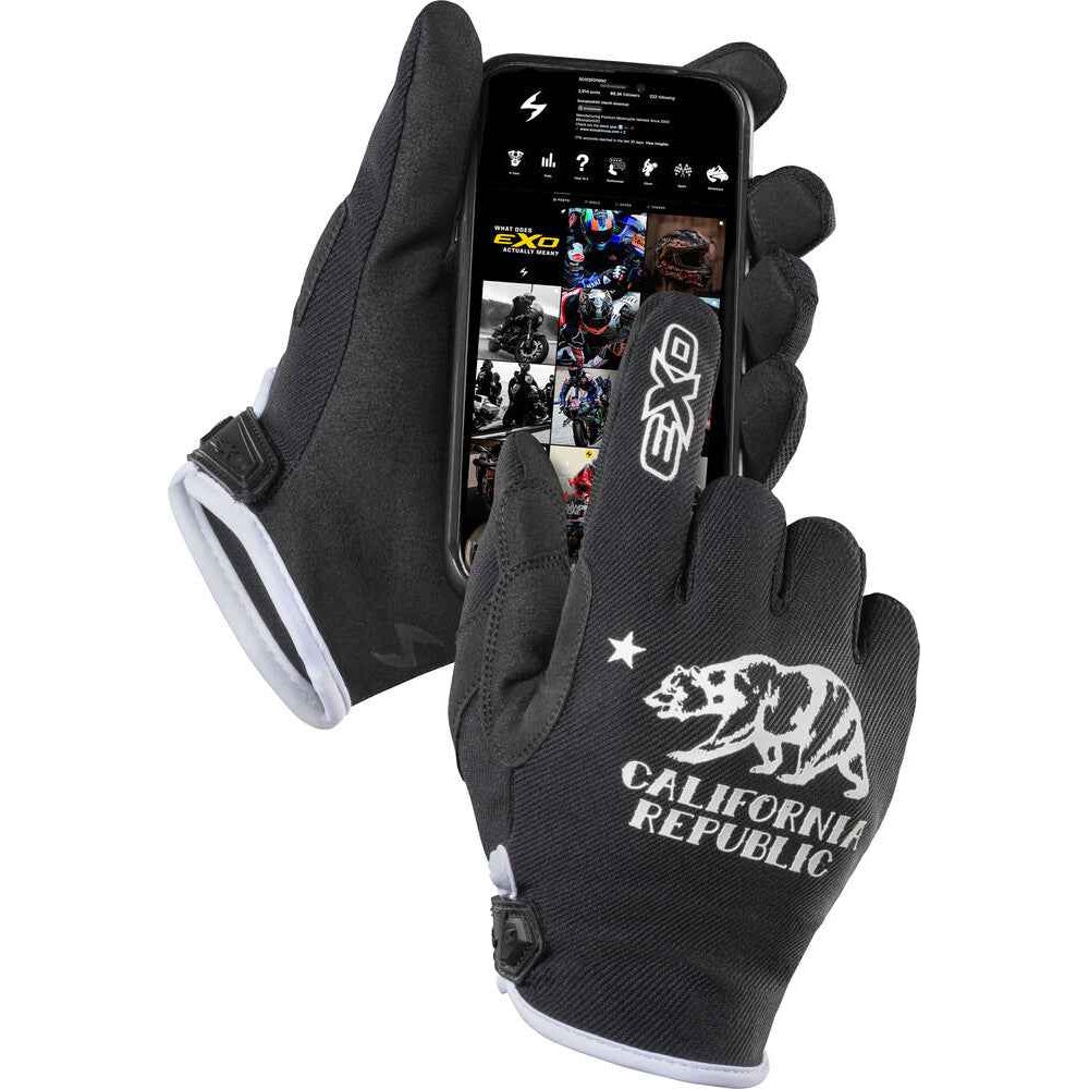 A pair of black touchscreen-compatible gloves with white accents, featuring a California Republic grizzly bear logo and text on one glove. One glove is holding a smartphone showing a motorcycle app, set against a plain white background.